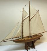 An early 20th Century clinker built pond yacht, twin masted with spinaker on bespoke stand,