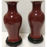 A pair of 19th Century Chinese sang de boeuf baluster shaped vases with flared rims raised on a