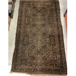 A Persian rug, the central panel set with all-over floral design in brown and cream,