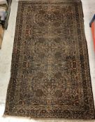 A Persian rug, the central panel set with all-over floral design in brown and cream,