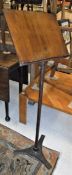 A Victorian cast iron adjustable music stand with walnut book rest