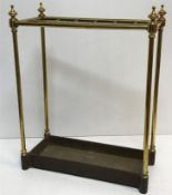A brass and iron twelve section stick stand on turned suppports united by a plain cast iron base
