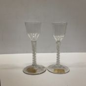 A pair of 18th Century glass wines with plain bowls on white enamel twist stems,