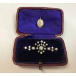 A diamond set bar brooch set with twenty-four varying sized diamonds and a diamond set