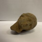 An early carved stone head as a Goddess looking left over her shoulder, her hair in a bun (poss.