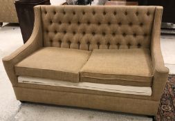 A modern buttoned upholstered two seat sofa bed in fawn upholstery,