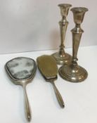 A collection of silver wares to include a pair of loaded silver candlesticks,