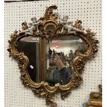 A modern gilt and simulated marble framed wall mirror in the Rococo style,