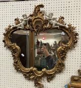 A modern gilt and simulated marble framed wall mirror in the Rococo style,