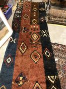 A tribal runner, the brown, blue, red block ground set with geometric design,