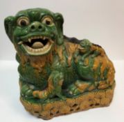 A near-matching pair of 19th Century Chinese Sancai yellow and green glazed figures of temple lions