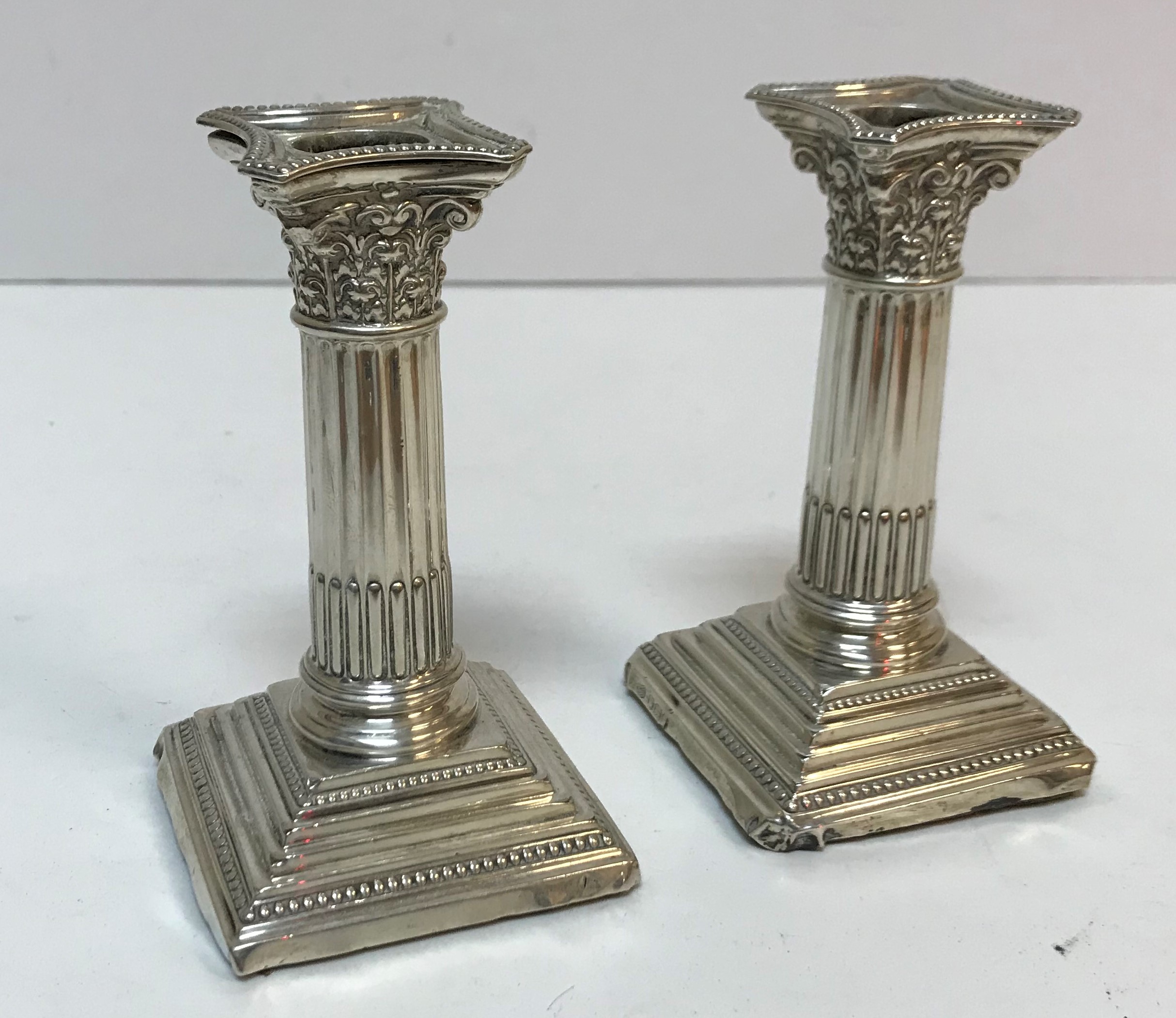 A pair of Corinthian column style candlesticks of small proportion (by Alexander Clark & Co.