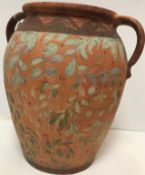 A terracotta and foliate hand painted two handled urn in the Cypriot manner 38 cm high x 34 cm wide