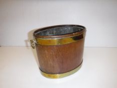 A George III mahogany and brass bound oval wine cooler of small proportions with lead lined