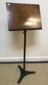 A mahogany adjustable music stand on a turned tapering pedestal to studded leather upholstered