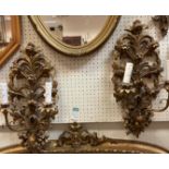 A pair of modern gold painted two branch wall lights with foliate and floral decoration in the