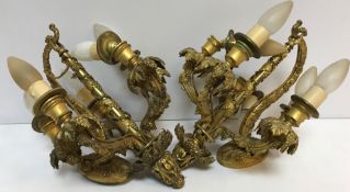 A pair of early 20th Century gilt brass wall lights as five branch candle holders with grape and