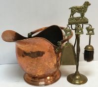 A Victorian copper coal helmet and cottage fireside companion set decorated with figure of a