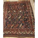 A Persian rug, the central panel set with all-over stylised flower head,