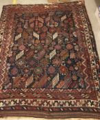 A Persian rug, the central panel set with all-over stylised flower head,