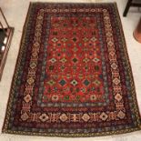 A Caucasian rug, the central panel set with repeating design on a red ground, within a stepped red,