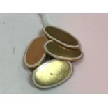 A pair of 18 carat gold and white enamel decorated oval cufflinks of plain form 7.