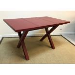A red leather covered dining table on end "X" trestle supports by Dominic Chambon of Paris, 130 cm