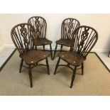 A set of four ash and elm stick back chairs in the 19th Century style, the shaped seats on turned
