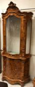 A modern Italian walnut and marquetry inlaid serpentine fronted display cabinet, the upper section