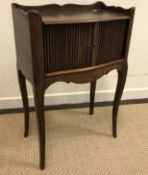 A French oak pot cupboard, the three quarter galleried top over two tambour doors and a shaped