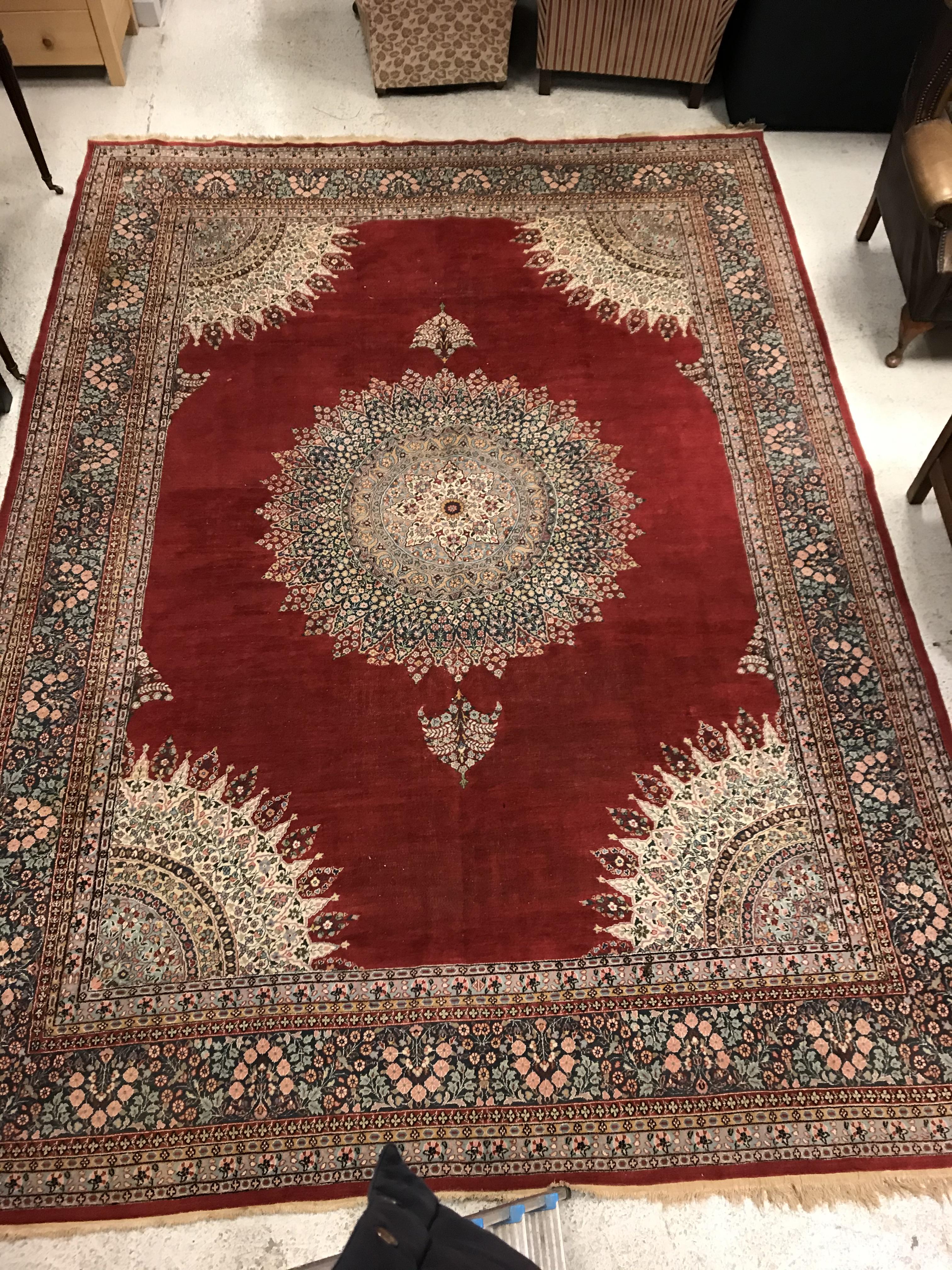 A large fine Oriental carpet, the central panel set with floral decorated circular medallion on a