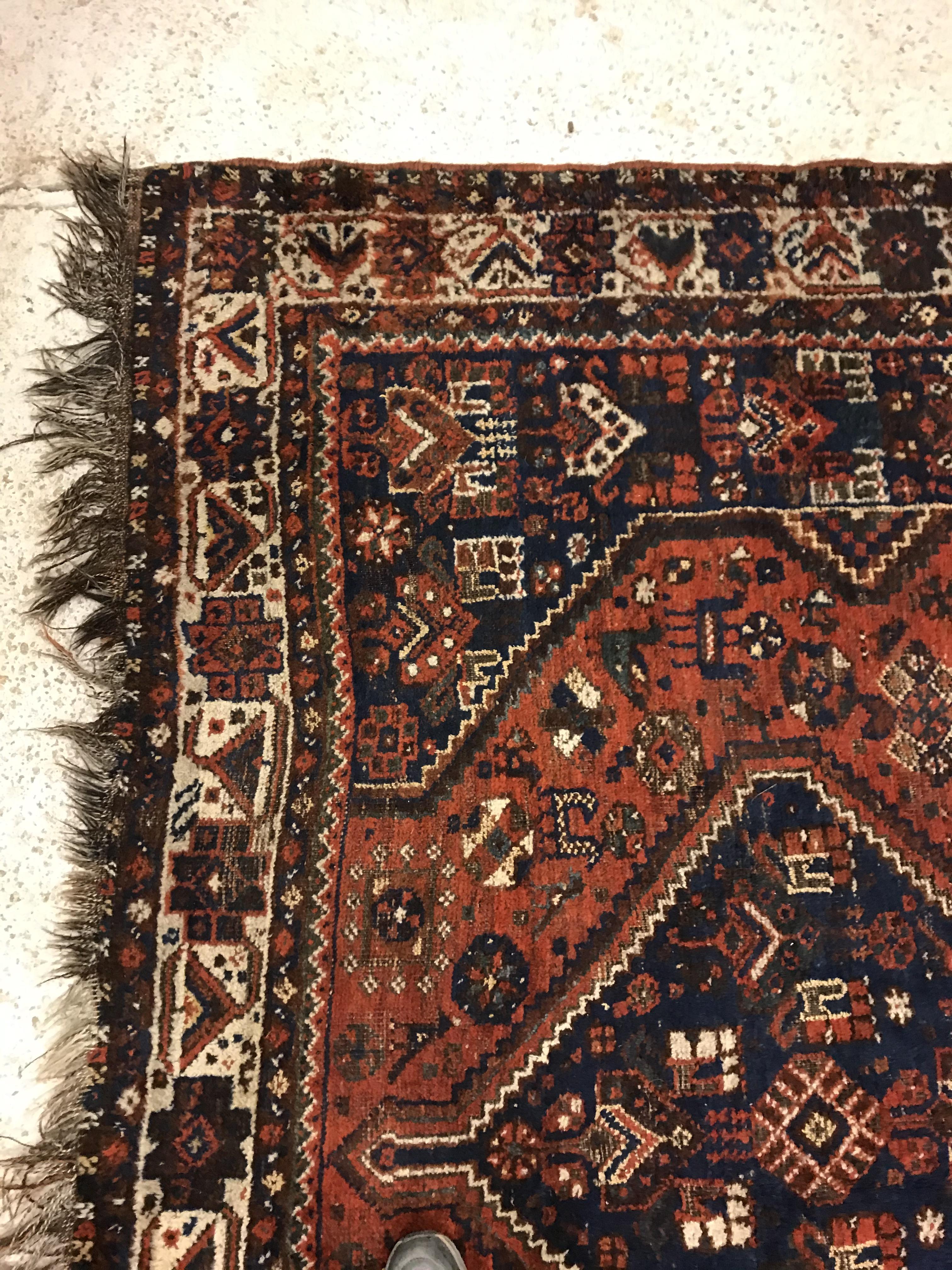 A Shiraz carpet, the central panel set with three joined diamond shaped medallions on a red and blue - Image 10 of 17