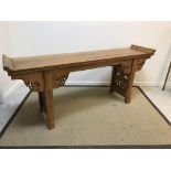 A Chinese elm altar table, the top with scroll ends above a cloud carved frieze on square supports