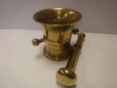 A 19th Century brass mortar of typical form with ring decorated flared rim and two lug handles,