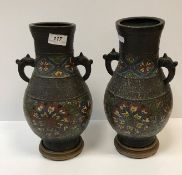 A pair of 19th Century Chinese bronze and cloisonné banded baluster shaped vases with kylin handles,