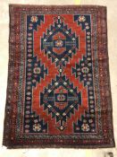 A Kasak rug, the central panel set with two repeating medallions on a red ground with stylised