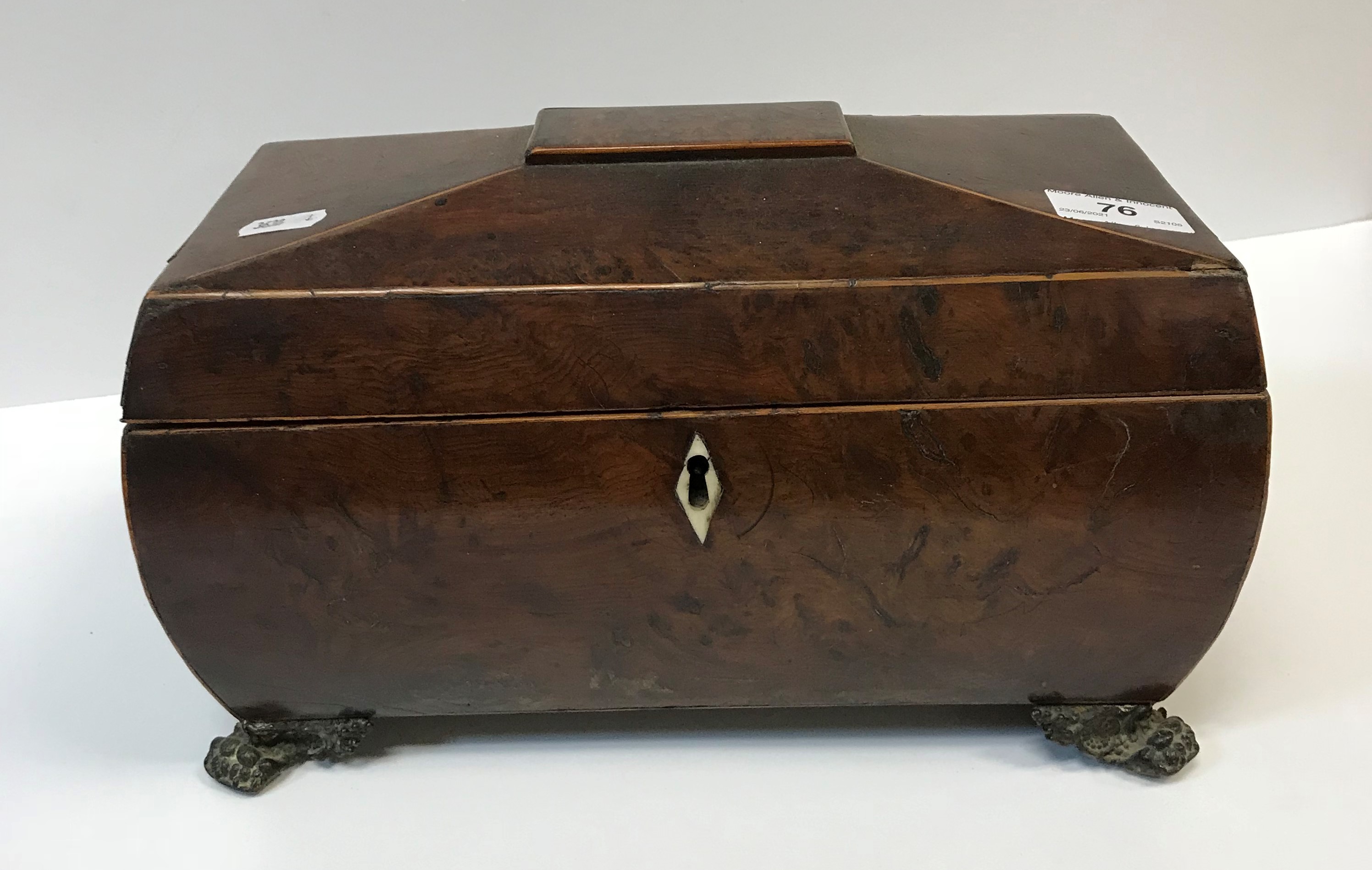 A 19th Century burr yew tea caddy of sarcophagus form, the top opening to reveal a central mixing