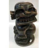 A 20th Century Ugandan carved ebony figure "Jabawoki", a squat fat bellied man, inscribed on label