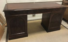 A Victorian mahogany sideboard, the plain top with moulded edge above three frieze drawers, raised