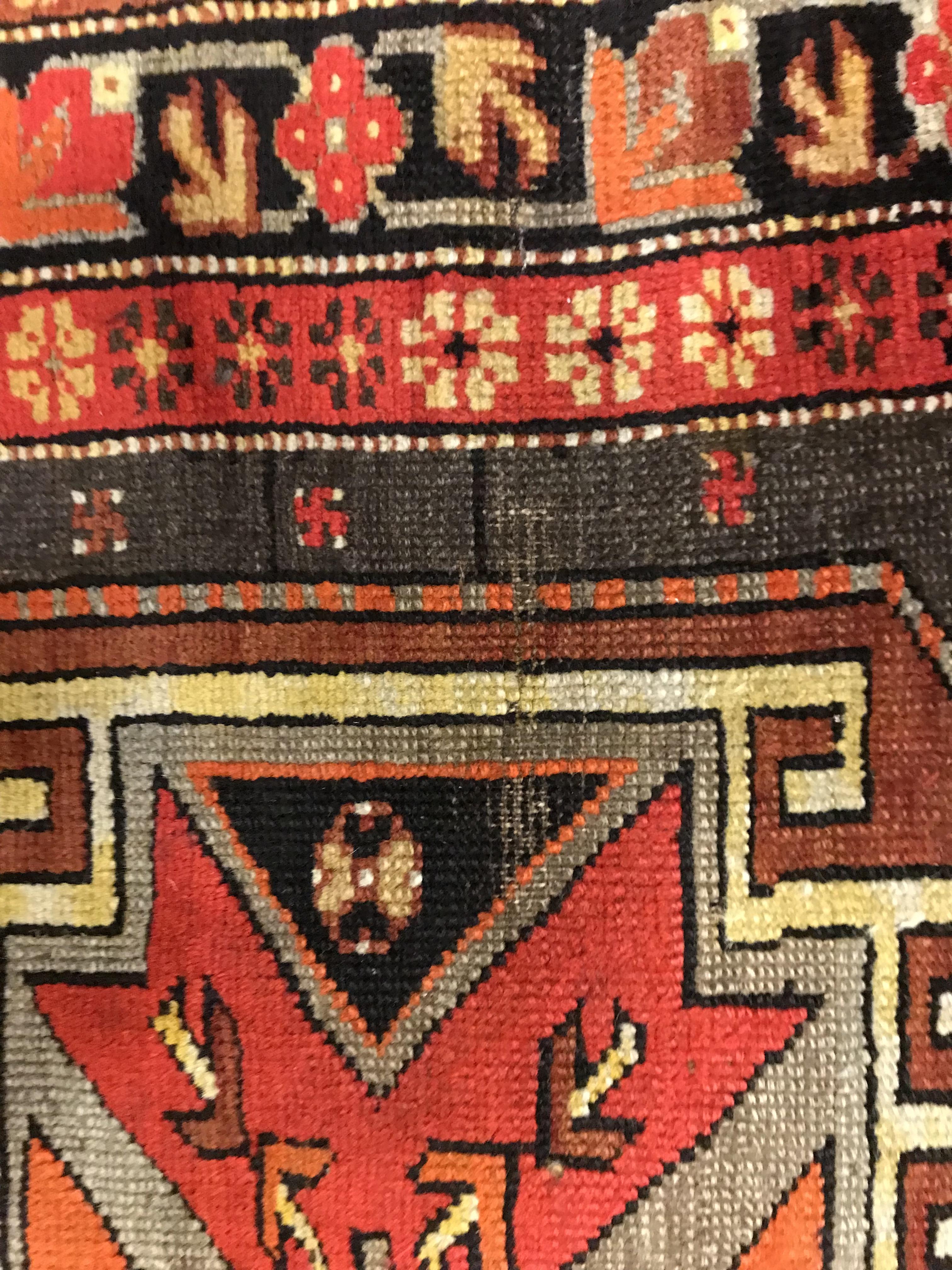 A Caucasian rug, the central panel set with three repeating medallions on a brown ground, within a - Image 6 of 10