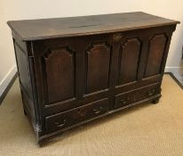 A late 18th Century oak mule chest, the rising top over four fielded arched panels and two drawers