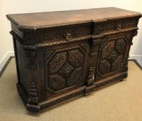 A late Victorian carved oak enclosed dresser in the Gothic Revival taste, the top with foliate