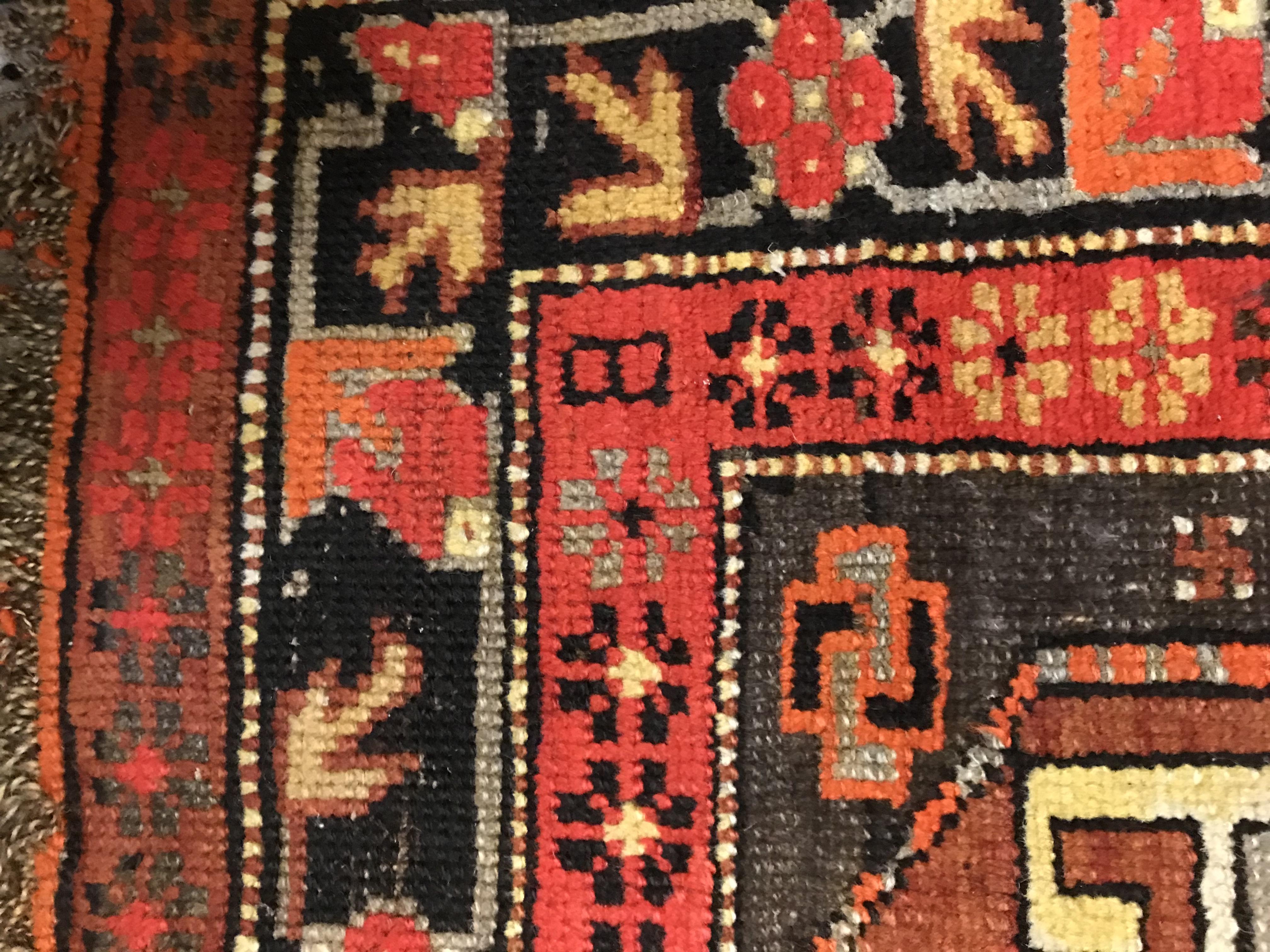 A Caucasian rug, the central panel set with three repeating medallions on a brown ground, within a - Image 8 of 10