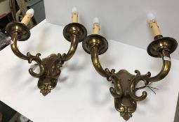 A pair of modern lacquered brass twin branch wall lights of scrollwork form in the Rococco style