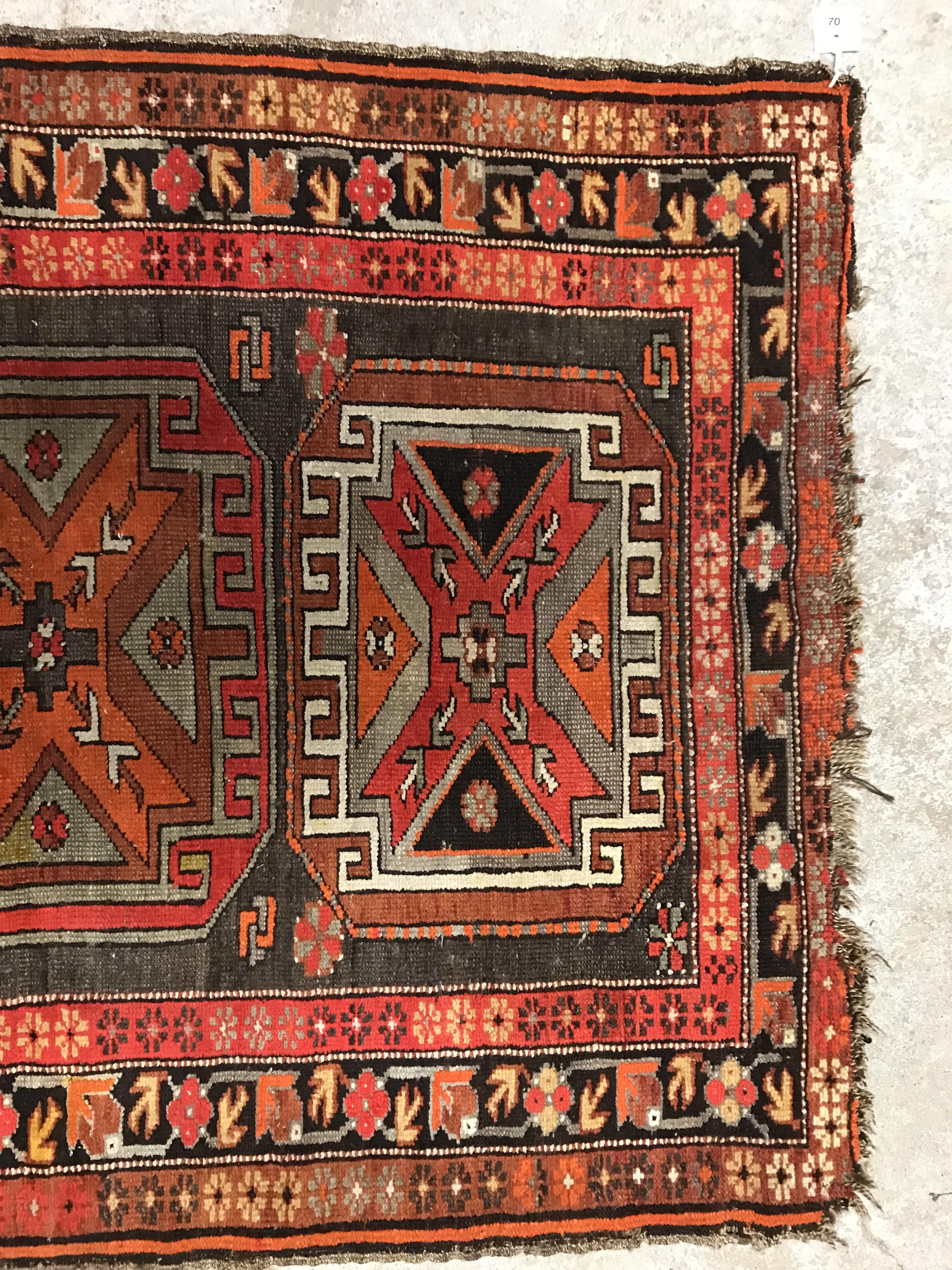 A Caucasian rug, the central panel set with three repeating medallions on a brown ground, within a - Image 4 of 10