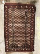 A Turkamen prayer rug, the central panel set with architectural design on an aubergine and cream