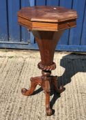 A Victorian rosewood work table of octagonal trumpet form, the top opening to reveal a fitted