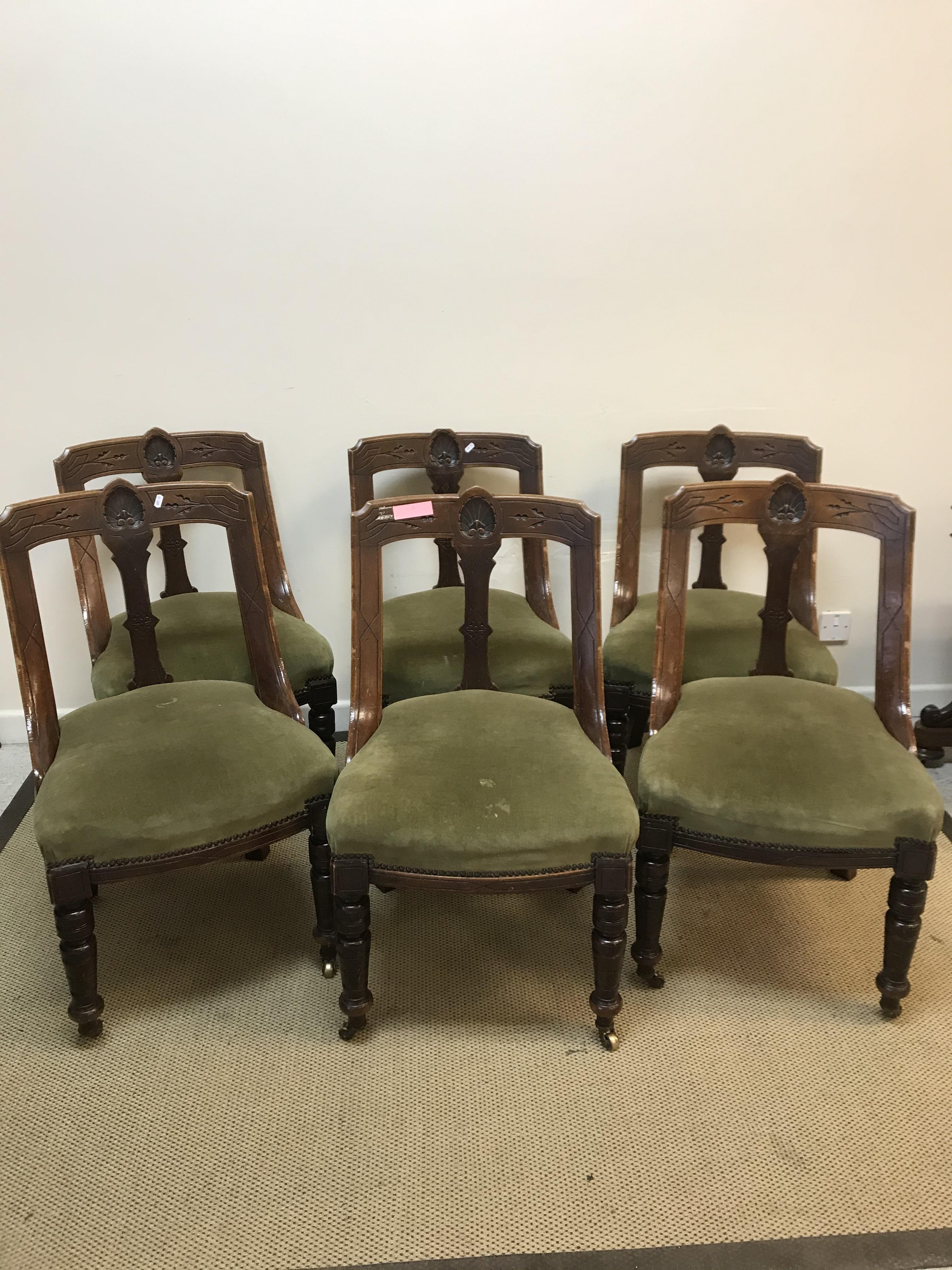 A set of six Victorian carved walnut framed shaped back dining chairs in the Aesthetic taste, raised