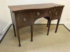 A 19th Century mahogany serpentine fronted sideboard with central drawer flanked by deep drawer