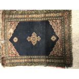 A Shenna rug, the central panel set with three medallions on a dark blue ground, within a red floral